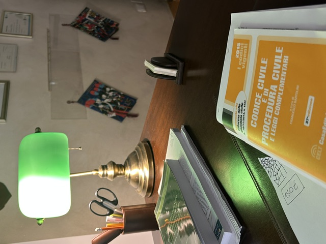 Scrivania con lampada da ufficio e Codice Civile nello Studio Legale V&V